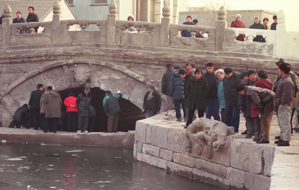 2000年12月21日，大批老北京市民前来观看重现历史风貌的后门桥。后门桥是京杭大运河的一处重要遗迹，又称万宁桥、地安桥。