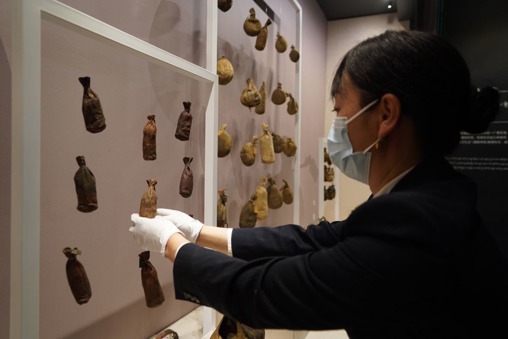 5月8日，在青海藏医药文化博物馆，展览策划部部长德吉卓玛正在整理展柜里放置的藏医药袋。新华社记者 耿辉凰摄