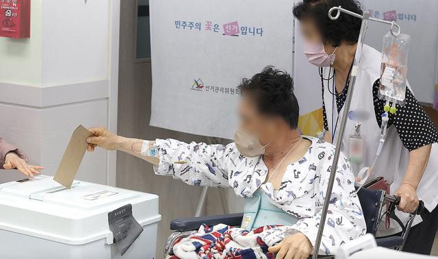 4月5日，在大邱市中区的三德洞行政福利中心投票站，临近医院的住院患者坐轮椅前来参加第22届国会议员选举缺席投票。