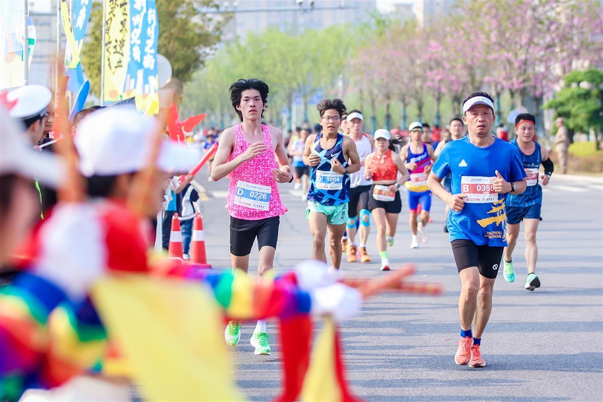 选手在奔跑,荆州志愿者和群众在赛道旁位选手加油.jpg