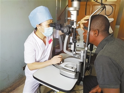 中国专家正在为贝宁当地患者进行眼科检查。本报记者 黄培昭摄