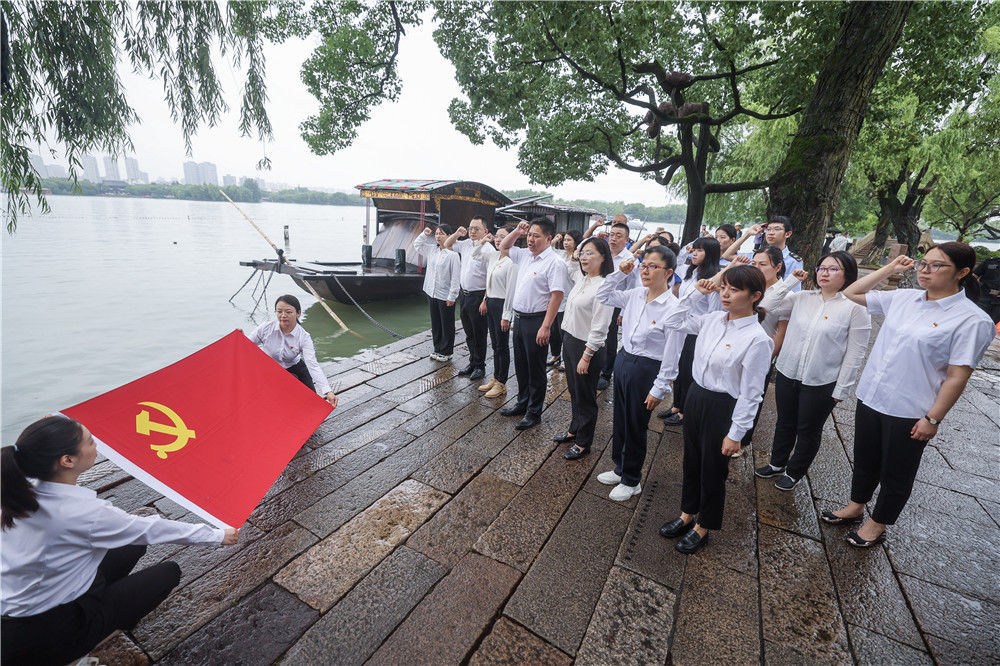 2024年6月28日，党员们在浙江嘉兴南湖红船旁重温入党誓词。新华社记者 徐昱 摄