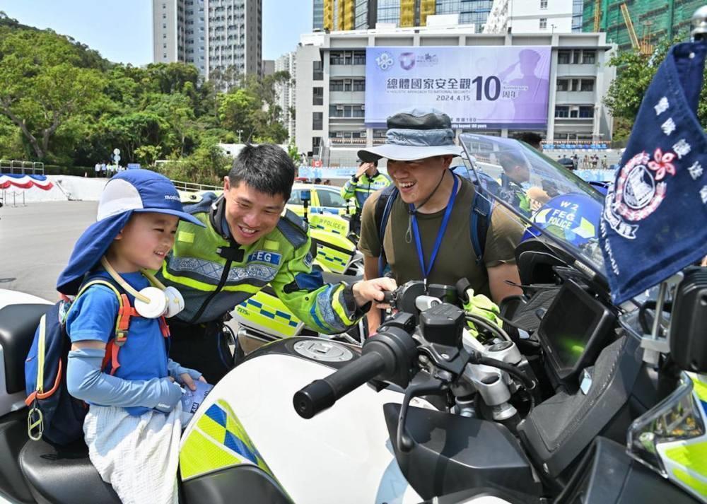 △2024年4月13日，香港特区政府警务处举行“全民国家安全教育日”暨香港警察学院开放日开幕典礼。这是13日当天，警队护送组人员现场向市民介绍其工作。