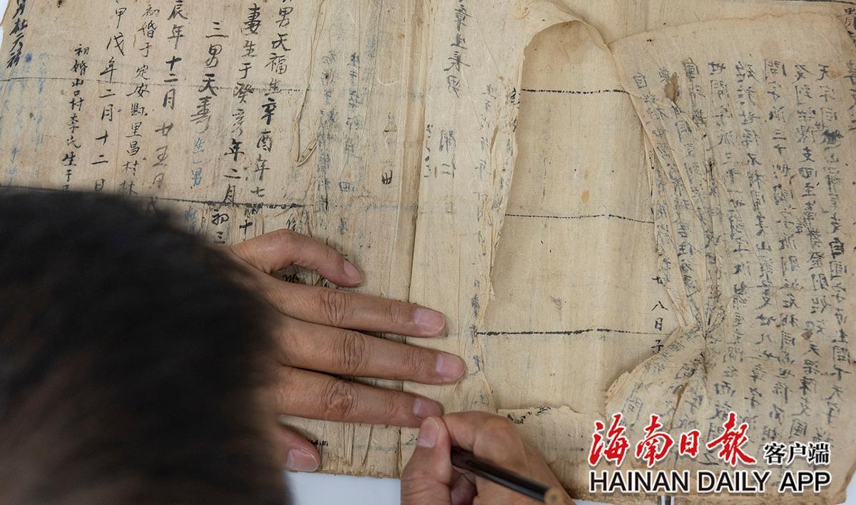 给古籍拆线前 ，黄文锋用铅笔标识页码 。海南日报记者袁琛 摄