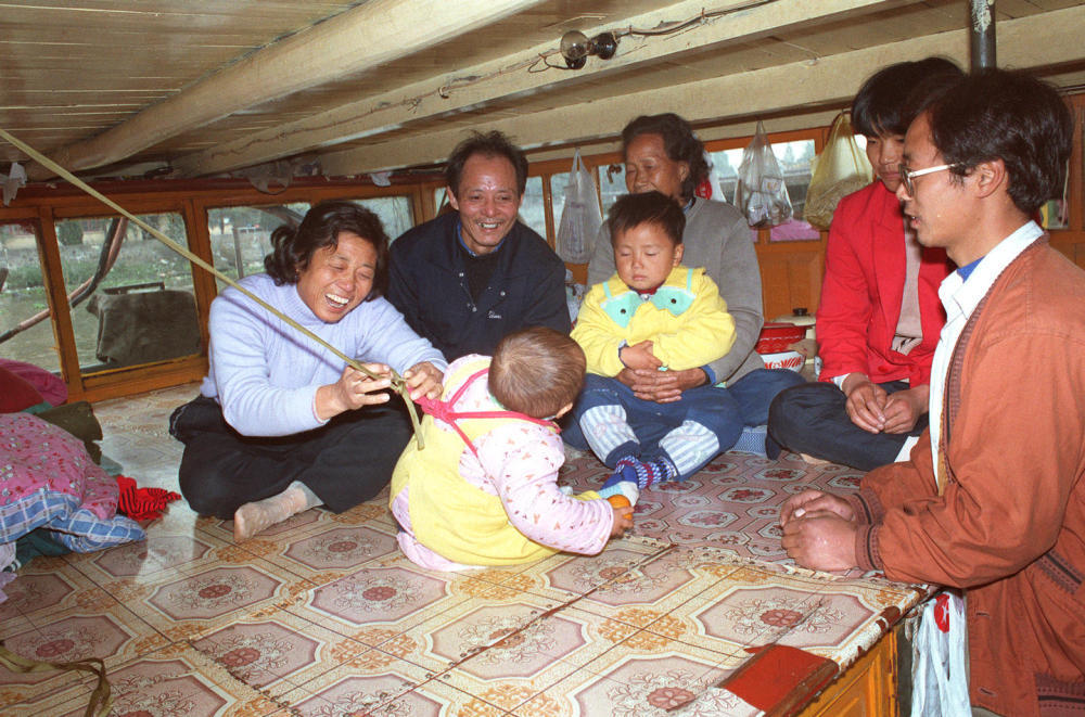 1997年， 浙江余杭老船民钱盛祥（左二）一家四代住在船上，古老的大运河成为他们一家生活的唯一指靠。