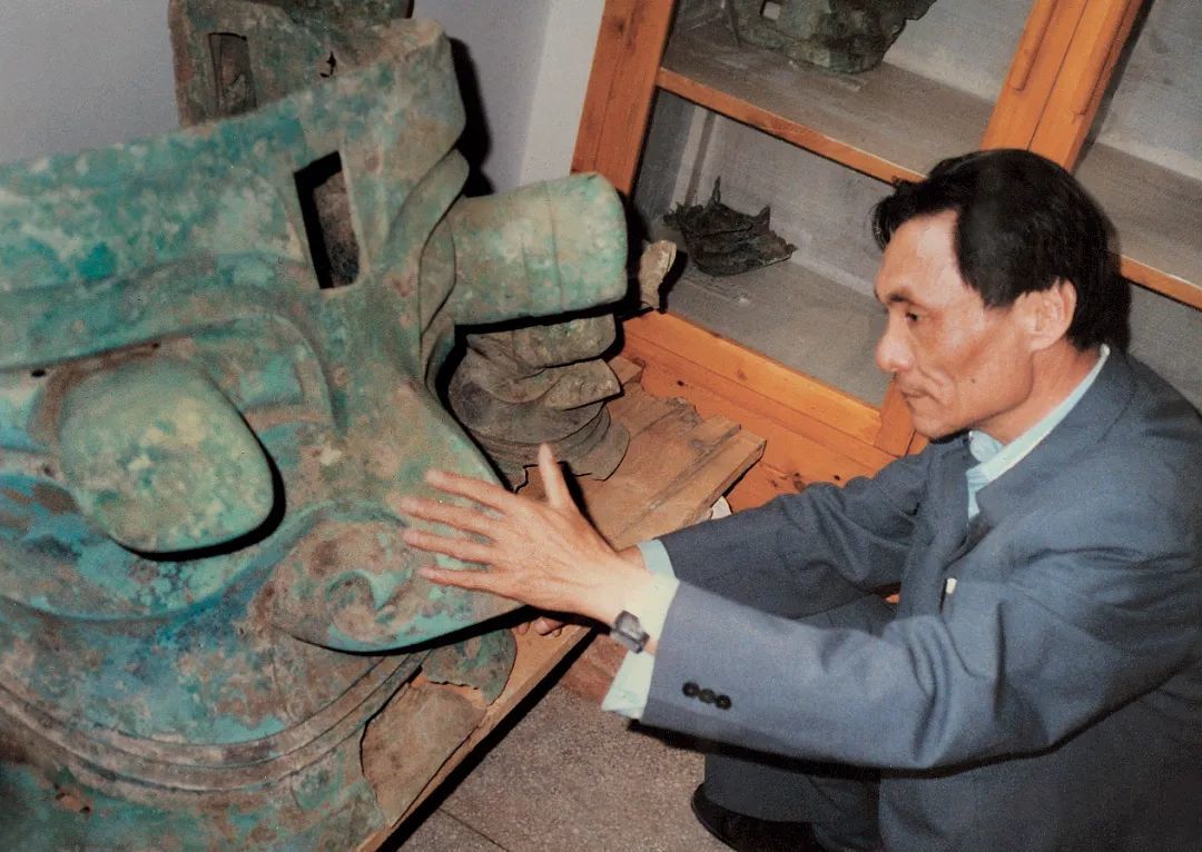 1987年，严文明观察三星堆出土青铜面具。图/北京大学新闻网