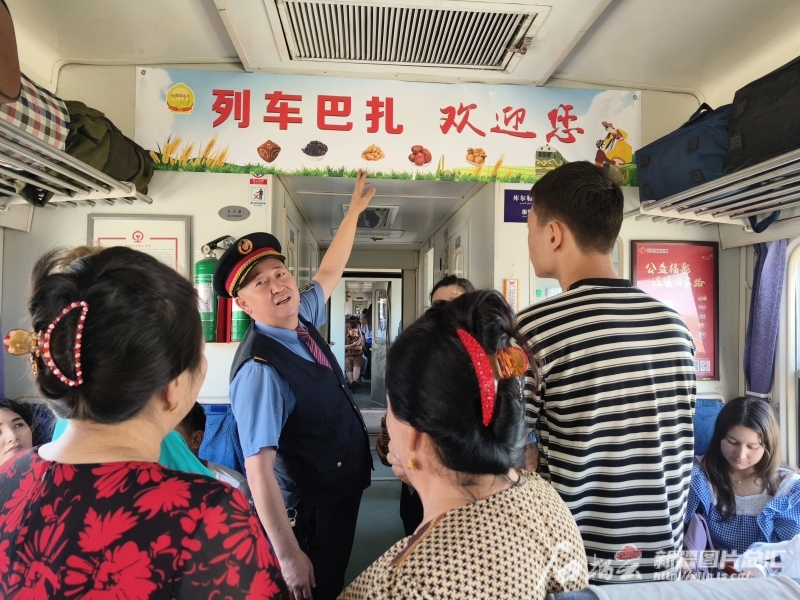 坡拉提汗向乘客介绍列车巴扎的基本情况。武耀帮摄