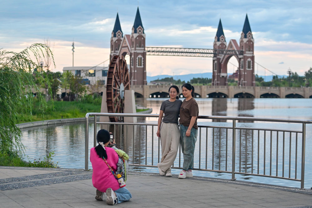 游客在新疆布尔津县七彩河休闲旅游度假区拍照（7月21日摄）。