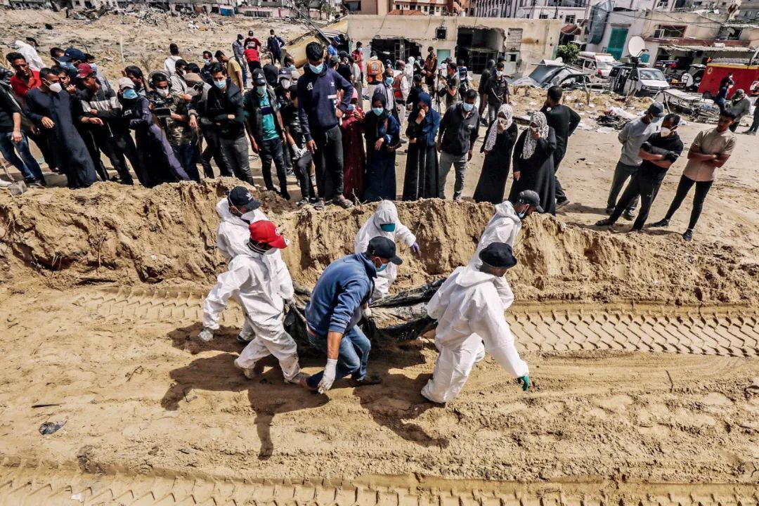 4月21日，加沙地带南部汗尤尼斯，卫生工作者在纳赛尔医院挖掘被埋的巴勒斯坦民众尸体。 图/视觉中国