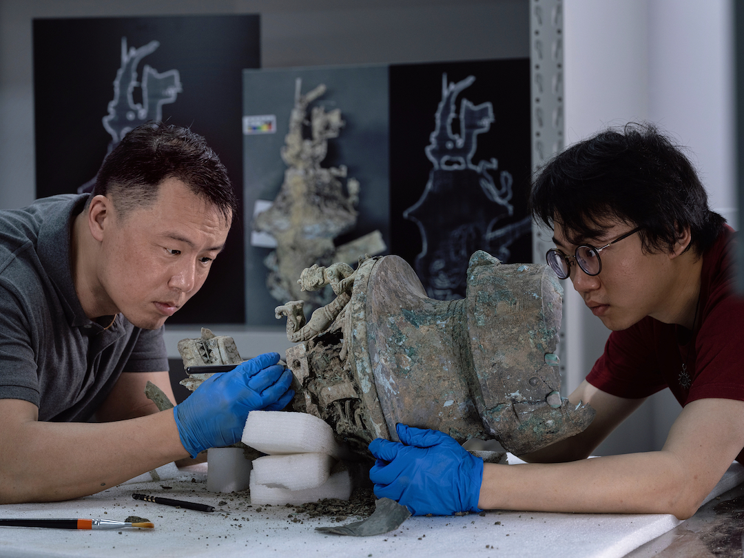 上博文物修复人员清理三星堆八号坑出土的神兽器盖及残尊