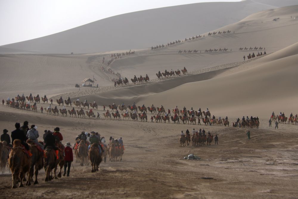 5月4日,游客在甘肃省敦煌市鸣沙山月牙泉景区游览。新华社发(张晓亮摄)