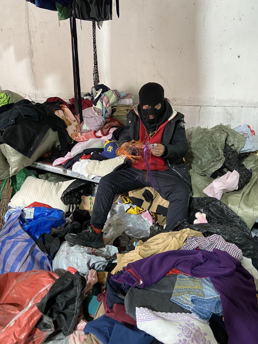 8、小海在仓库干活挑选衣服,捡起一个头套戴上,发泄内心苦闷.jpg