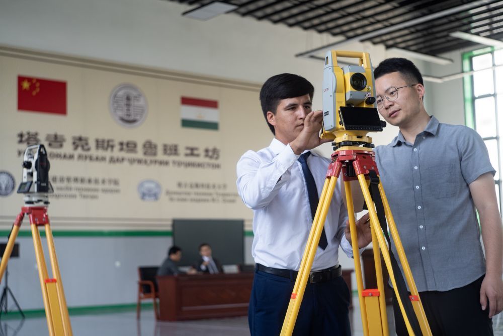 6月14日，来自天津城建学院的教师与在塔吉克斯坦鲁班工坊学习的当地学生交流技术经验。