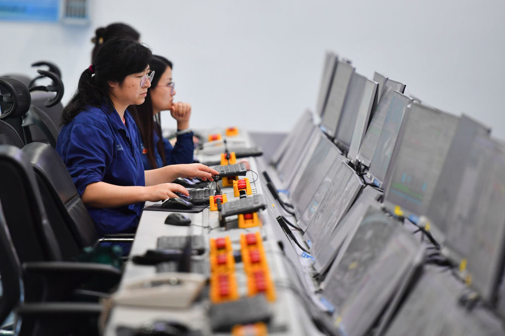 ↑2024年6月13日，在位于湖南省湘潭市的湘潭钢铁集团有限公司五米宽厚板厂智慧中心，工作人员在远程操作加热炉设备。五米宽厚板厂智慧中心利用超融合、虚拟化、5G传输以及分布式计算和存储等技术，将五米板炼钢、轧钢和热处理全工序的控制和二级、三级系统进行整合，改善工人的工作环境，提高生产的自动化程度和效率。新华社记者 陈泽国 摄