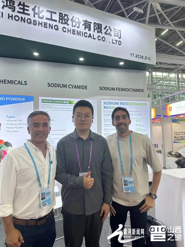 图为山西鸿生化工股份有限公司展位负责人张晋强与境外采购商合影。