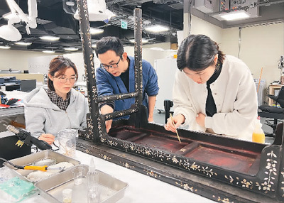 京港修复师共同为明代黑漆嵌螺钿桌案进行“会诊”。香港故宫文化博物馆供图