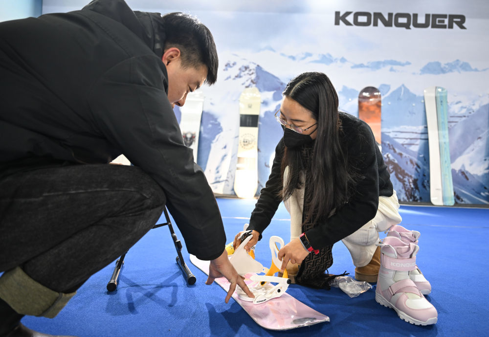 ↑2023年12月16日，参展人员在首届呼伦贝尔&middot;海拉尔冰雪产品冬季展销会上为顾客展示单板固定器产品。新华社记者 贝赫 摄