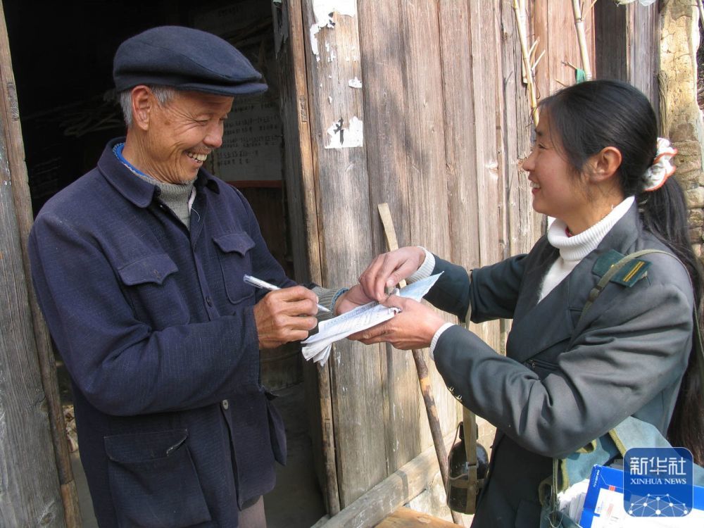 罗细英把信件送到居民手中（2007年1月6日摄）。 新华社记者陈春园摄