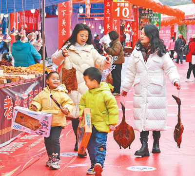 四川广安市前锋区近日举行2024年迎新春购年货展销活动，吸引了大量市民前来购买年货。图为市民在迎新春购年货展销活动上满载而归。张启富摄（影像中国）