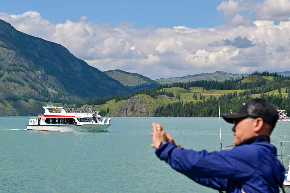 游客在新疆阿勒泰地区喀纳斯景区观光游览（7月22日摄）。