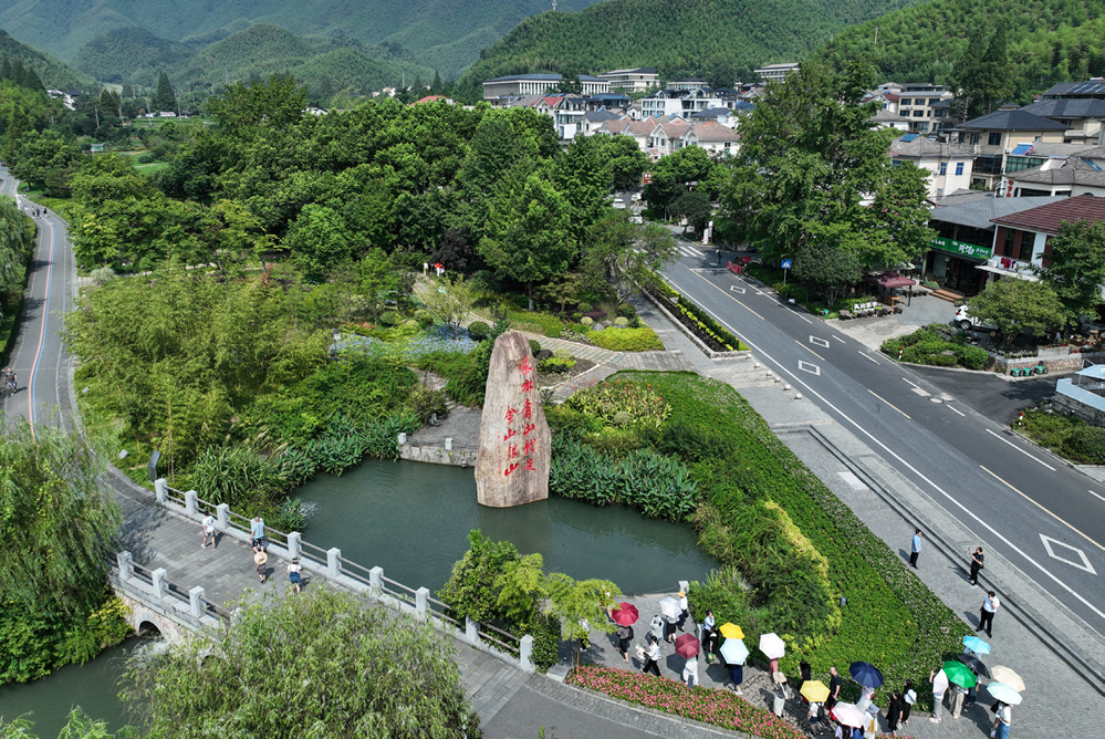 游客在浙江安吉余村的绿水青山间参观（2023 年 8 月 11 日摄）翁忻旸摄 / 本刊