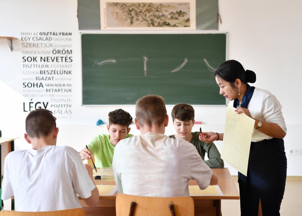 2023年2月24日，在匈牙利首都布达佩斯的匈中双语学校，中国教师指导学生们学习书法。新华社记者连漪摄