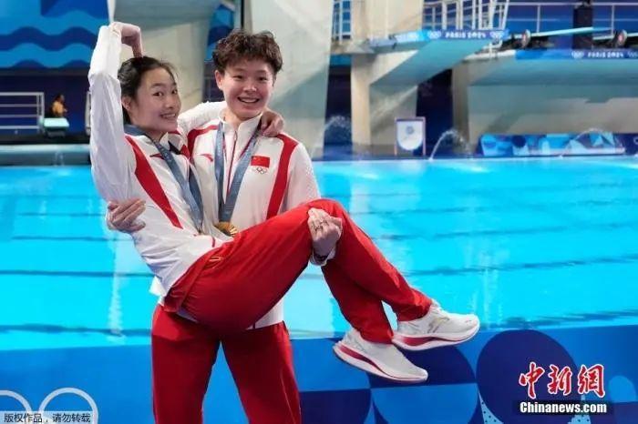资料图:跳水女子双人3米板颁奖仪式上,金牌得主陈艺文“公主抱”了搭档昌雅妮。