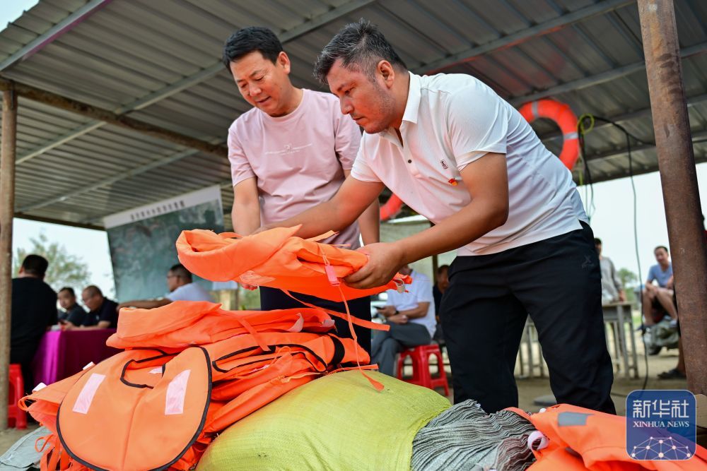 ↑在新疆阿克苏地区沙雅县盖孜库木乡吐央村，抢险人员在整理防汛物资（8月3日摄）。新华社记者 丁磊 摄