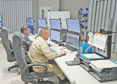 在奇姆肯特炼厂中控室内，操作员正在监控装置运行参数。本报记者 谢亚宏摄