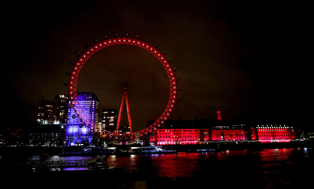 英国伦敦的泰晤士河边，“伦敦眼”摩天轮为庆祝中国农历新年而亮起红色灯光。