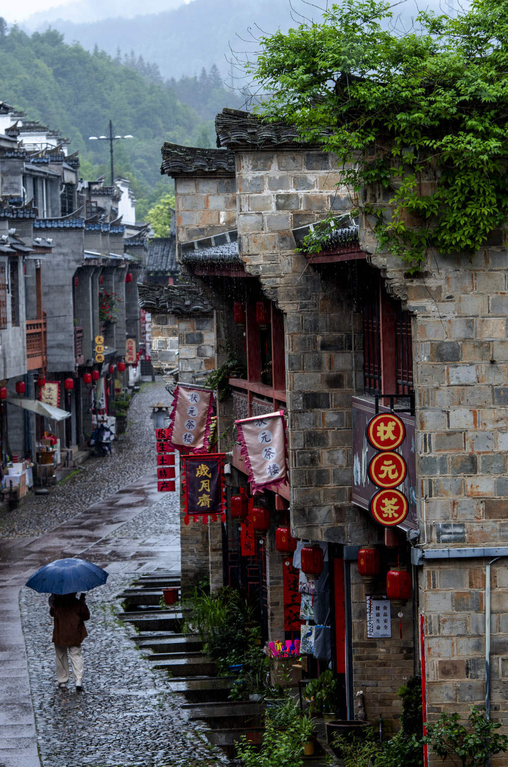 居民撑伞走在泰宁县尚书巷历史文化街区（4月19日摄）。