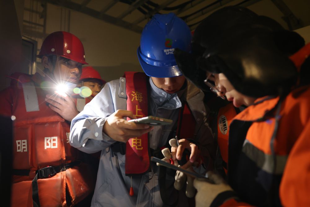 工作人员正在一台海上风力发电机组内部连夜排查故障.(汤博文摄)