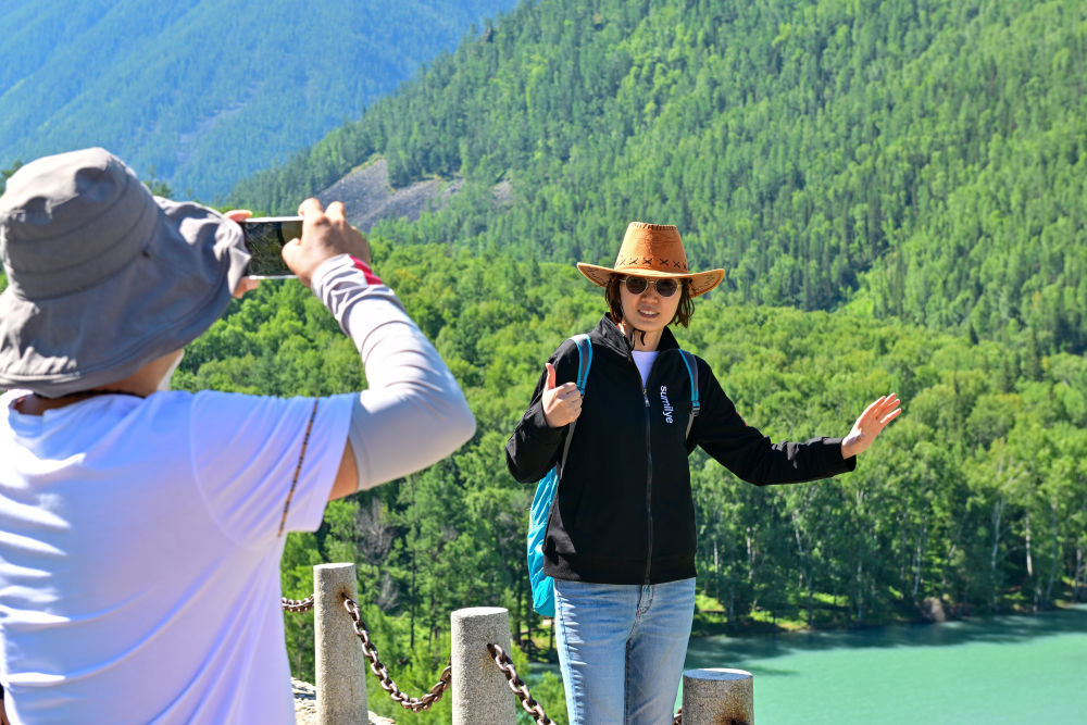 游客在新疆阿勒泰地区喀纳斯景区观光游览（7月22日摄）。