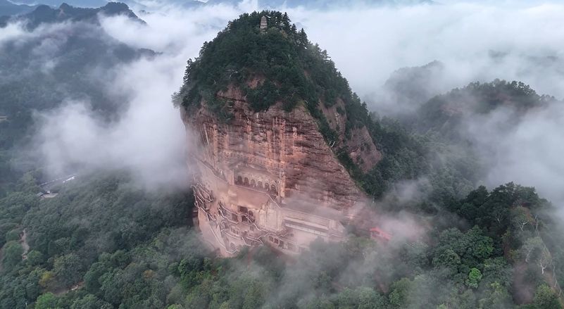 云雾笼罩中的麦积山。新华社发