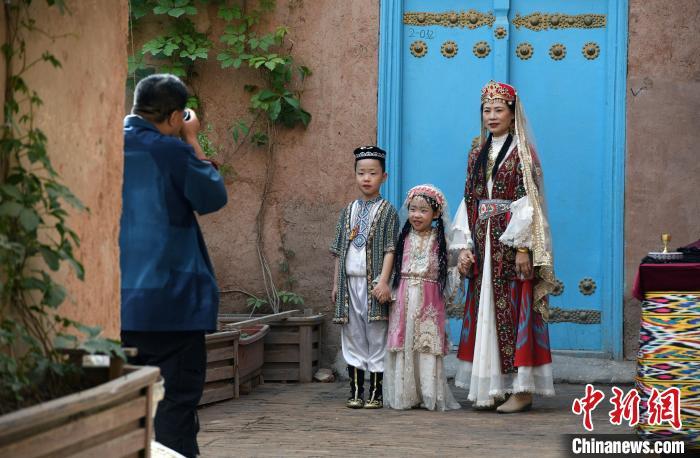 5月4日，游客带着孩子在喀什古城旅拍。中新网记者 孙亭文 摄