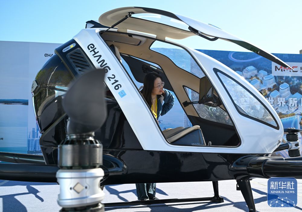 ↑4月27日，在新疆特种旅游节特种旅游装备展上，游客在了解一架自动驾驶飞行器。