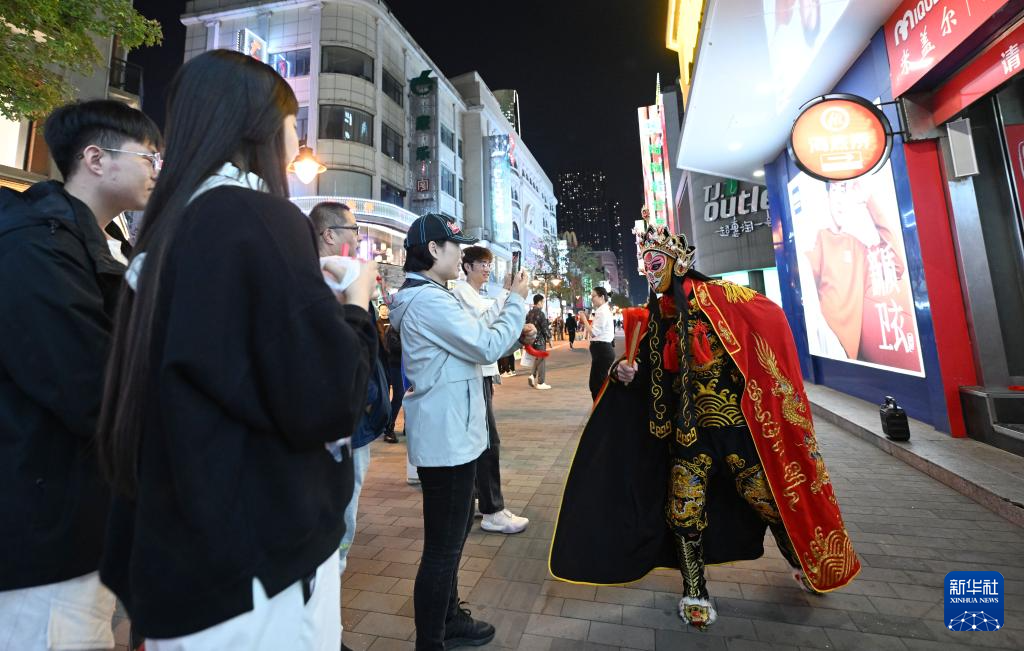 10月16日，市民、游客在金街观看演出。新华社记者 赵子硕 摄