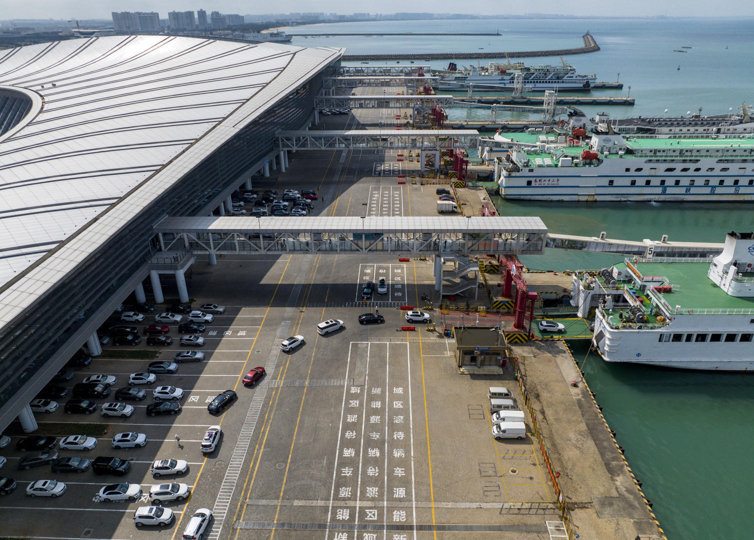 2024年2月5日，海口新海港码头，车辆排队登船。今年的琼州海峡春运期间运输需求旺盛，自1月26日春运以来即进入车客流高峰且大幅增长，春运前10天，琼州海峡进出岛旅客116.97万人次、车辆27.31万辆次，同比分别增长31.8%、17%。与以往不同的是，今年春运南北两岸车客流量均持续高位运行，且大货车占比较往年高；船舶和港口满负荷运行，高峰期南岸待渡车辆高达近6000辆。（无人机.jpg