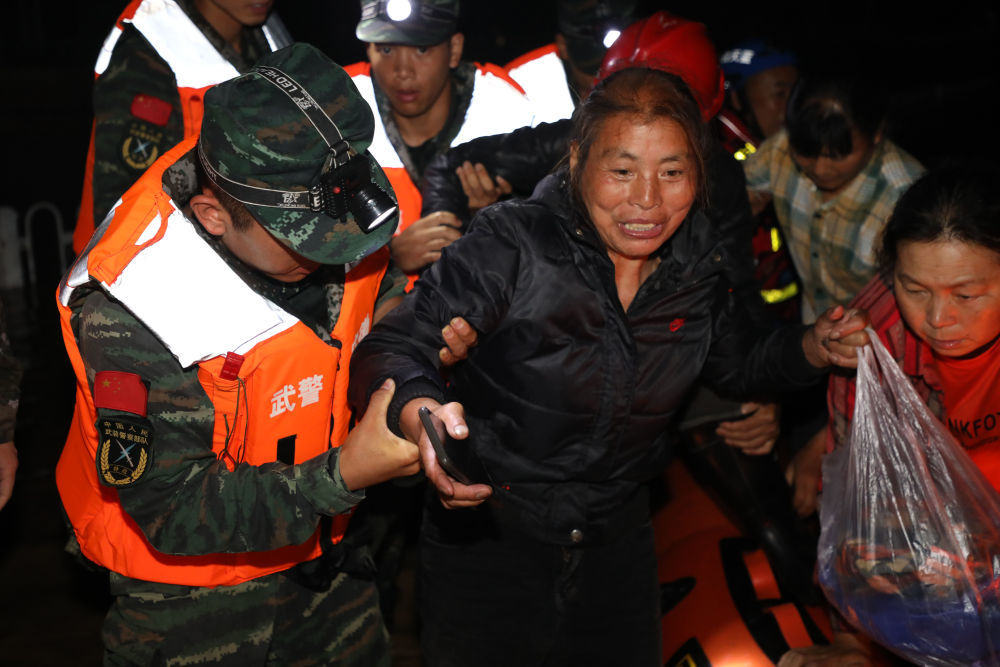 6月20日，武警安徽总队黄山支队官兵在黄山市歙县用皮划艇解救被洪水围困的群众。新华社发(曹浏 摄)