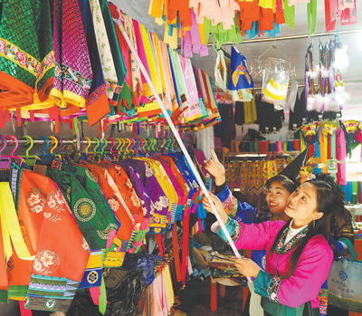 广西柳州市融水苗族自治县良寨乡的大集上，当地群众在选购苗族服饰，喜迎春节。龙 涛摄（影像中国）