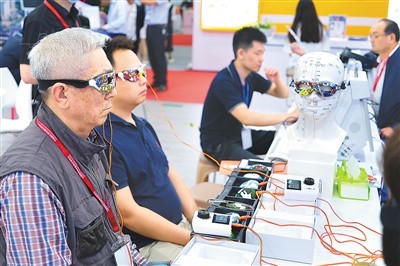 图为近日，观众在第十届中国国际养老服务业博览会上体验“多效经穴激活治疗仪”。郭俊锋摄（人民视觉）