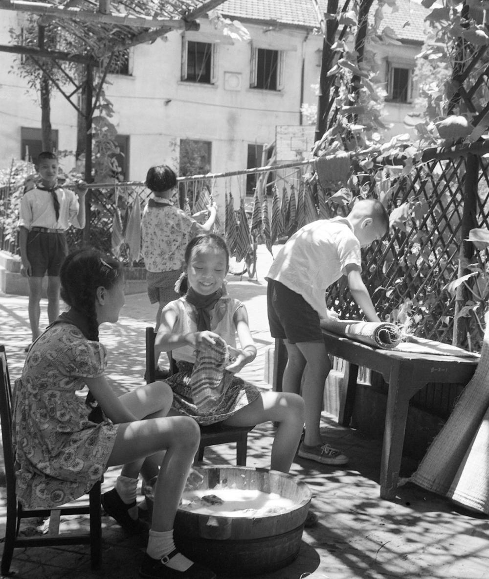 1963年,上海淮海中路小学的少先队员们正在给淮海中路幼儿园洗手巾、擦凉席。