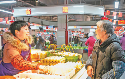 江西吉安吉水县新建的城北吉湖菜市场日前开业,更好满足市民需求。图为顾客(右)向商户询价。廖 敏摄(人民视觉)