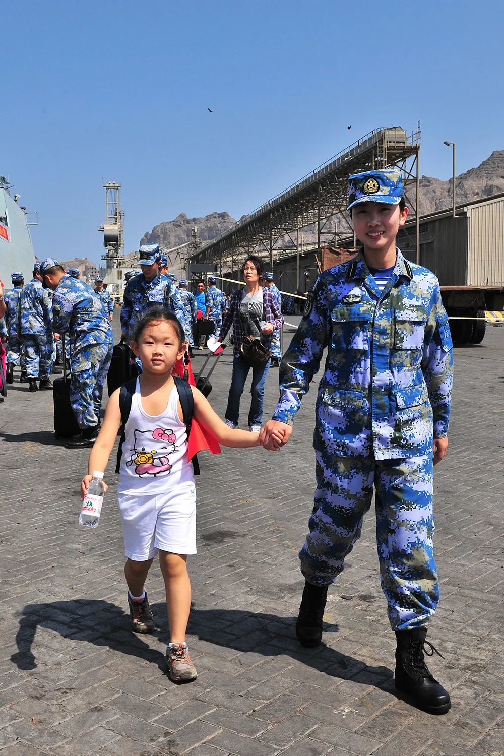 2015年3月29日，中国海军第十九批护航编队临沂舰抵达也门亚丁港，临沂舰女舰员帮助撤离的儿童登舰。新华社发（熊利兵 摄）