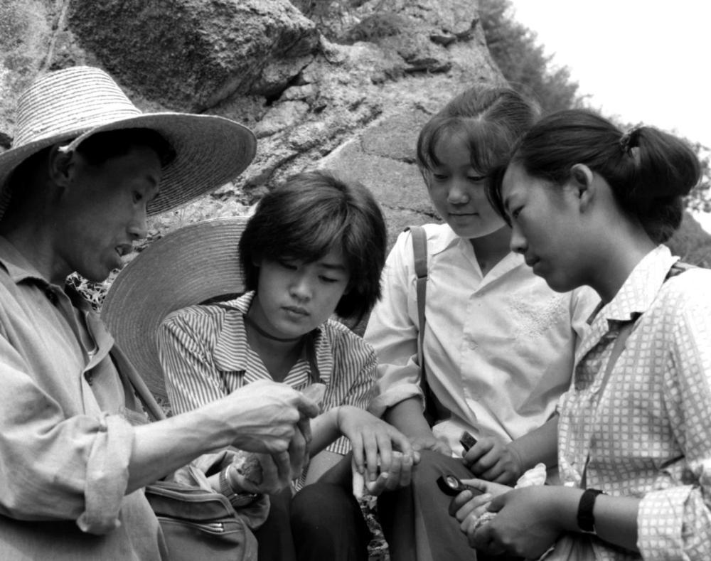 1979年,北京市中学生地质夏令营的同学在十三陵山区学习辨认岩石标本。