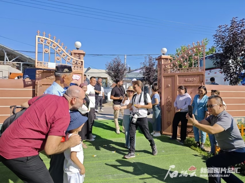 土耳其媒体人士在新源县那拉提镇英加尔村迎接“恰秀”礼仪。石榴云/新疆日报记者 宋海波摄