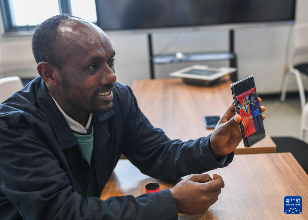 2月15日,在亚的斯亚贝巴的埃塞俄比亚联邦职业技术培训学院,鲁班工坊当地教师约纳斯·阿凯莱(中文名艾友涵)展示在中国学习时的照片。