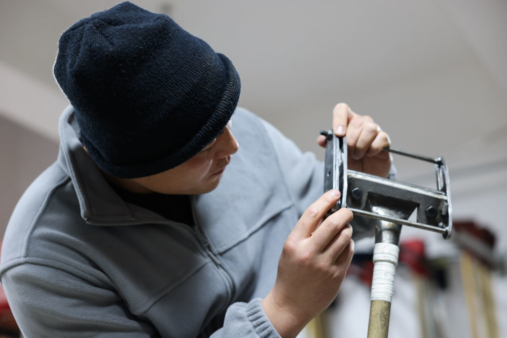 ↑2023年11月23日，李大伟在工作间调整修冰刀角度。新华社记者 王楷焱 摄