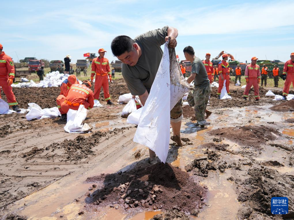 7月8日，岳阳军分区民兵和地方救援人员在湖南省岳阳市华容县团洲垸钱团间堤封堵管涌。新华社发（黎宇 摄）