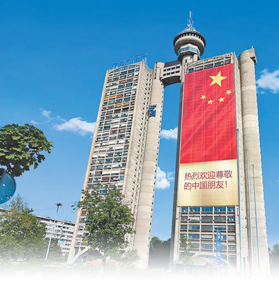 塞尔维亚首都贝尔格莱德市内的建筑上悬挂起巨幅五星红旗和中文标语，欢迎习近平主席到访。本报记者 谢亚宏摄
